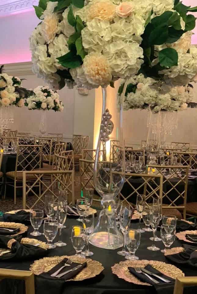 Elegant floral wedding reception setup at Paradise Ballrooms Elegant floral wedding reception with tall white hydrangea centerpieces and sophisticated table sett.