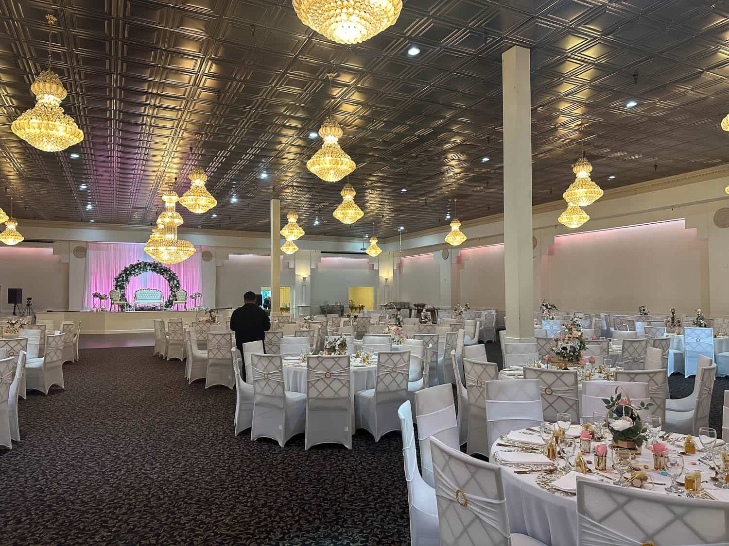 Beautiful ballroom decorated for weddings and celebrations with round tables and floral centerpieces.