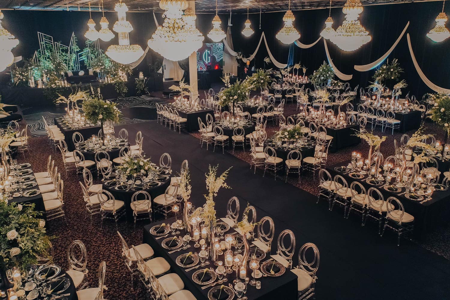 Elegant ballroom wedding reception with luxurious chandeliers and floral centerpieces.