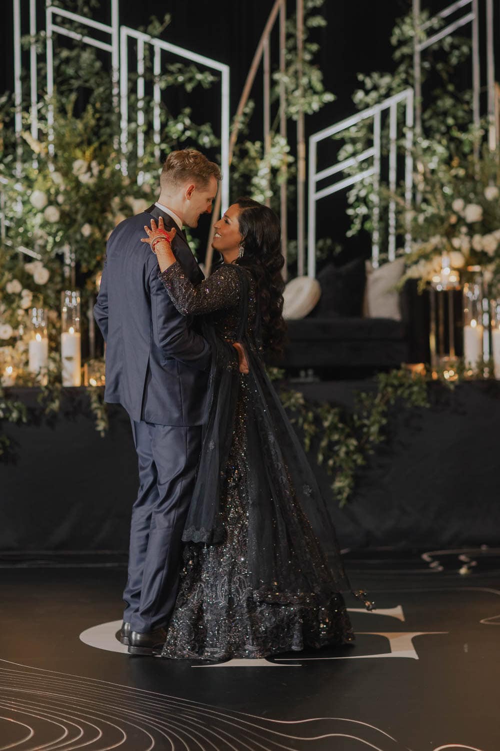 Couple dancing at Paradise Ballrooms with elegant decor and floral arrangements in the background.