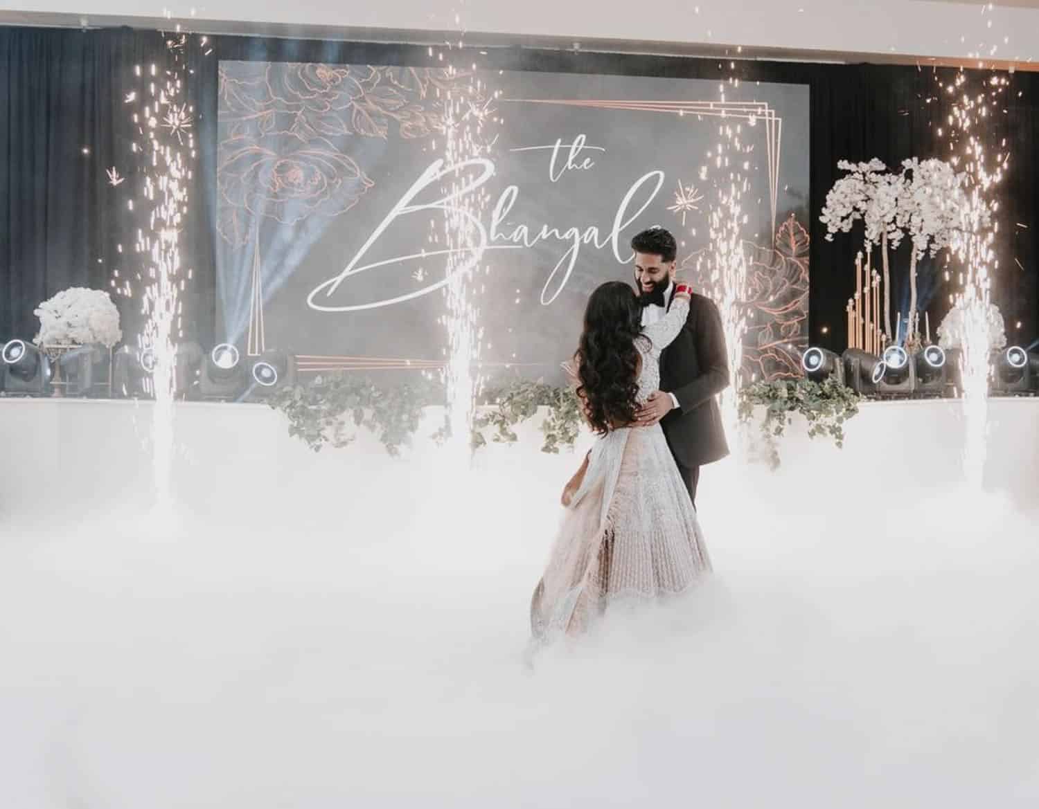 Elegant wedding couple dancing at Paradise Ballrooms with fog effects and sparklers.