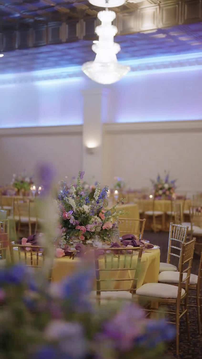 Elegant ballroom with floral centerpieces and ambient lighting.