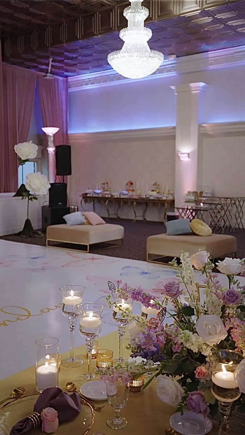 Elegant ballroom decorated for a special event with floral arrangements and candlelit ambiance.