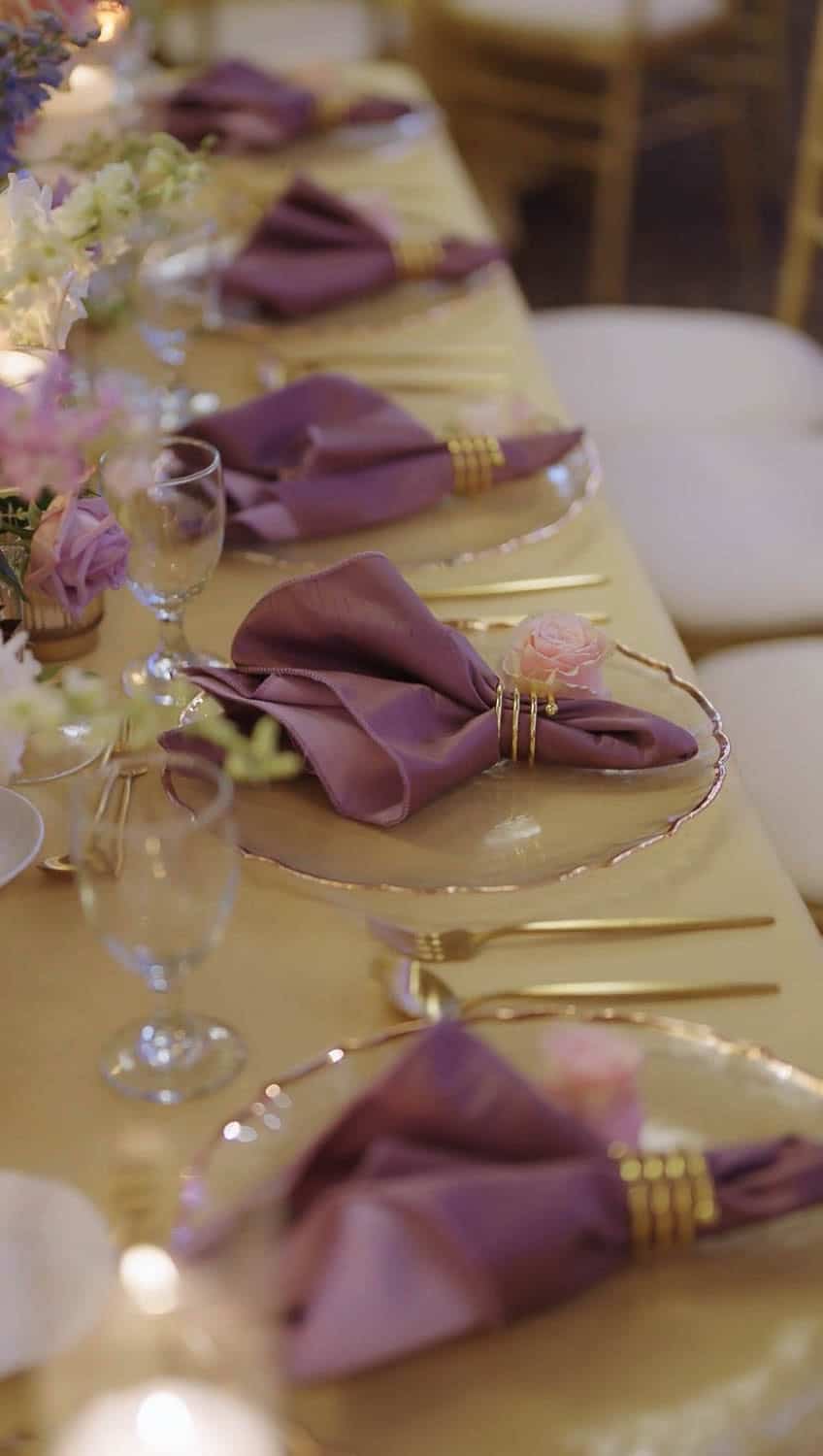 Beautifully arranged event table with purple napkins and floral centerpieces at Paradise Ballrooms.
