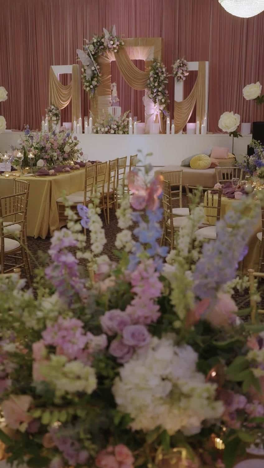 Beautifully decorated wedding reception with floral arrangements and elegant drapery.