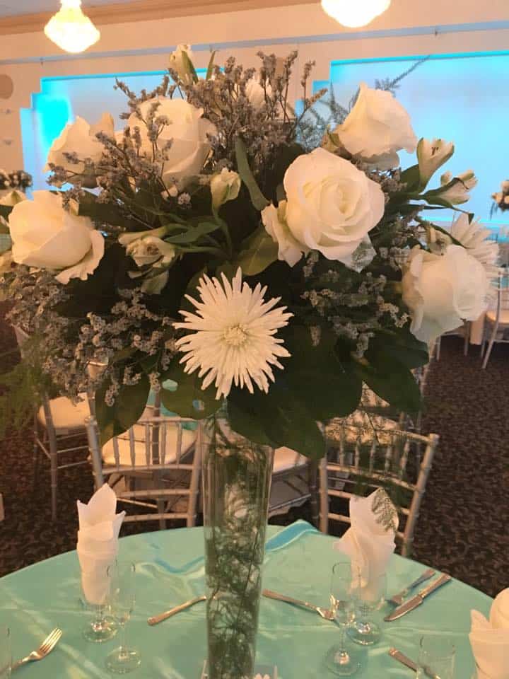 Elegant white rose floral arrangement for wedding and event decor.